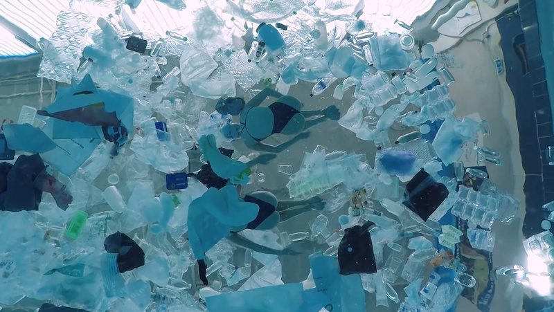 Pływaczki w basenie pełnym plastikowych śmieci
